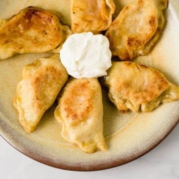 Easy homemade pierogies filled with two different fillings including cheddar mashed potato and caramelized onions with sauerkraut.