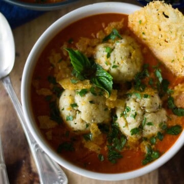 Creamy roasted tomato soup with cheesy matzo balls full of ricotta and Parmesan. It's the best of both cultures!