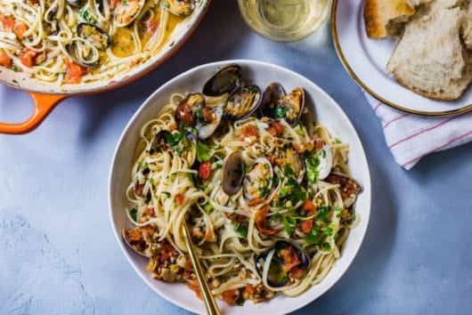 Classic linguini and clams recipe with a touch of white wine, tomatoes for sweetness and a gorgeous garlic sauce that wraps around each pasta strand.