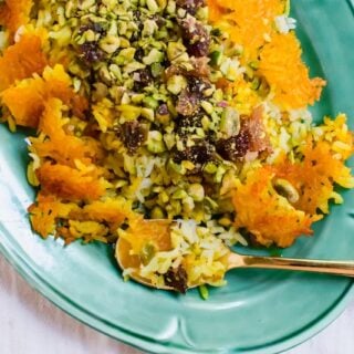 Persian rice with dates, chopped pistachios and aromatic cardamom is steamed together with an additive and crunchy saffron crust called tahdig.