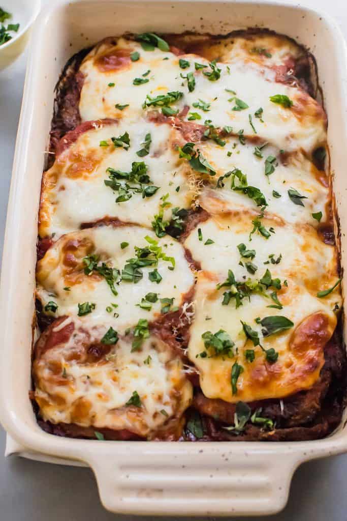 Sprinkle fresh herbs such as basil and oregano on top of classic eggplant parmesan.