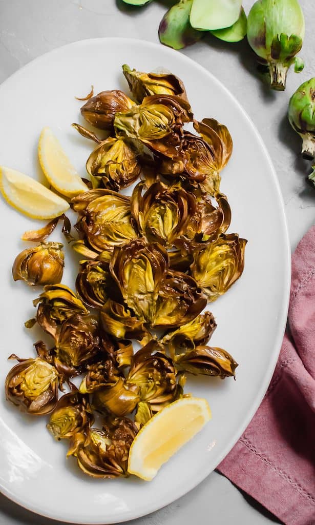 Baby artichokes are fried gently in olive oil until crisp and then seasoned simply with sea salt and lemon juice. 