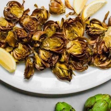 Roman style fried artichokes. Crispy baby fried artichokes fried in olive oil served with flakey salt and lemon juice. #FriedArtichokes #RomanFriedArtichokes