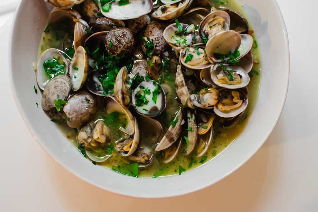 Steamed clams are cooked together with wine wine, garlic, a touch of butter and loads of fresh herbs. And have extra crusty bread ready to soak up the delicious broth.