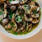 Steamed clams are cooked together with wine wine, garlic, a touch of butter and loads of fresh herbs. And have extra crusty bread ready to soak up the delicious broth.