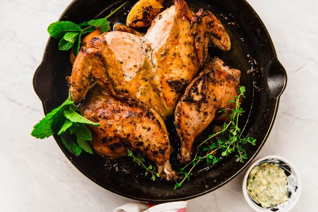 Spatchcock chicken in cast iron with lemon herb compound butter. 