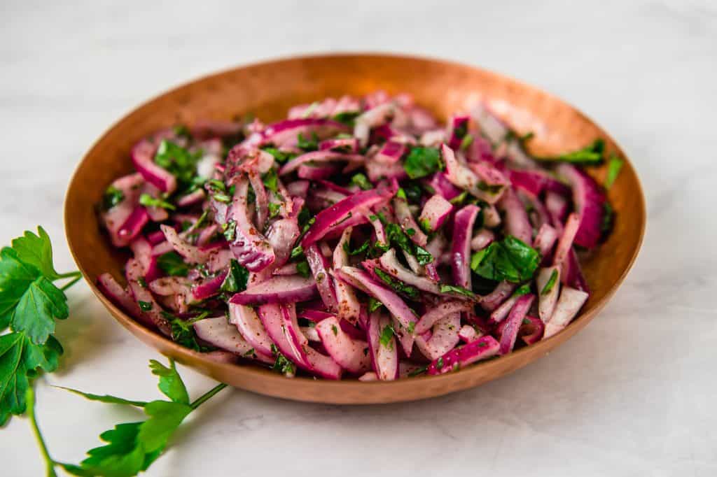 The perfect condiment to topped grilled meats, this Turkish sumac onion salad has thinly sliced red onions tossed with bright sumac, fresh parsley and fresh lemon juice.