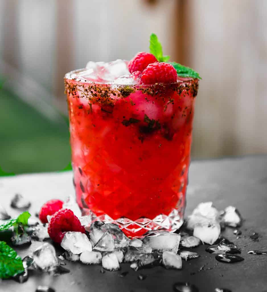 Smoky, slightly sweet and a bit tart, this  refreshing mezcal cocktail is muddled with fresh raspberries and mint and garnished with a Tajin rim.