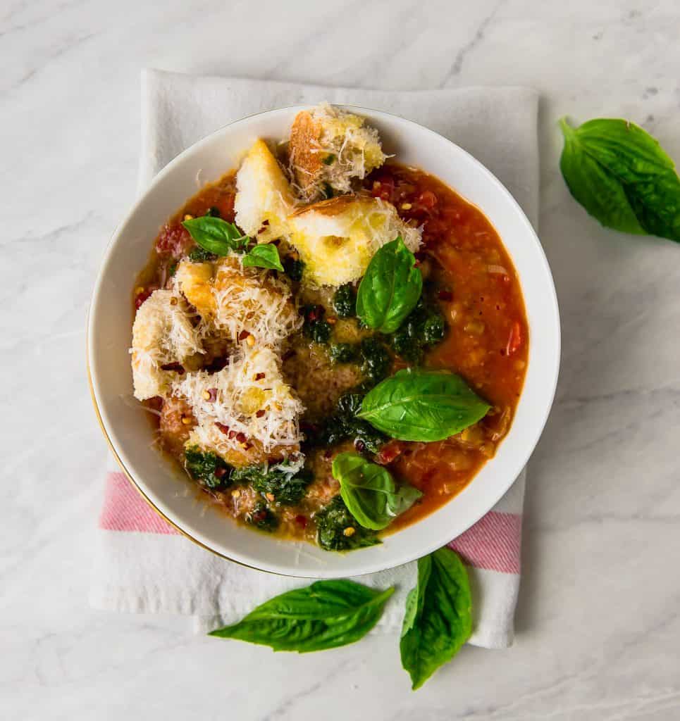 Tuscan bread soup also called ribollita is a hardy vegetarian soup thickened by day old bread, sweet tomatoes and finished with a bright basil oil and a good grate of Parmigiano Reggiano.