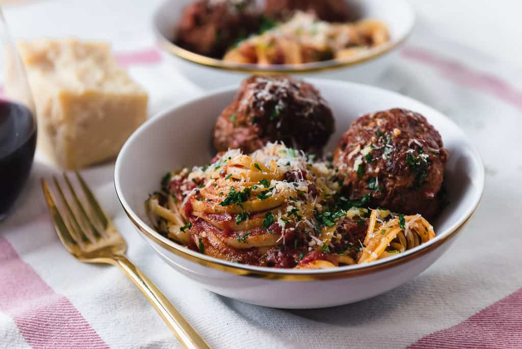 Homemade meatballs with Sunday gravy is a true labor of love. Meatballs are mixed with three meats and seasoned with flavorful aromatics which are then simmered in marinara for hours making them incredibly tender and flavorful. 