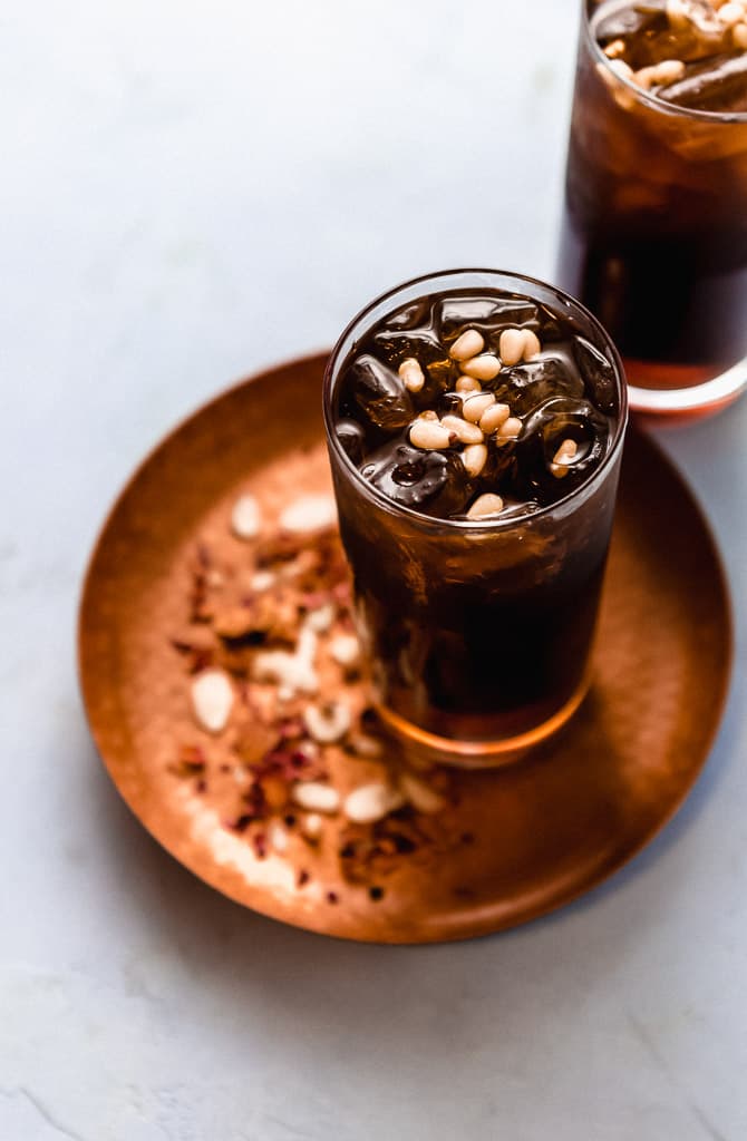A floral and refreshing Middle Eastern drink inspired from Lebanon, Jallab is made with date molasses, a touch of rose mater and topped with pine nuts.
