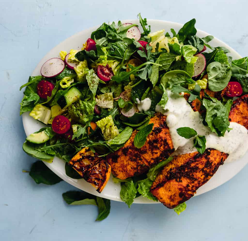 Inspired from bold flavors of chicken shawarma, this salmon shawarma salad uses the same marinade for intense flavors. Served on top of a crisp crunchy salad  and finished with a creamy dill sauce.