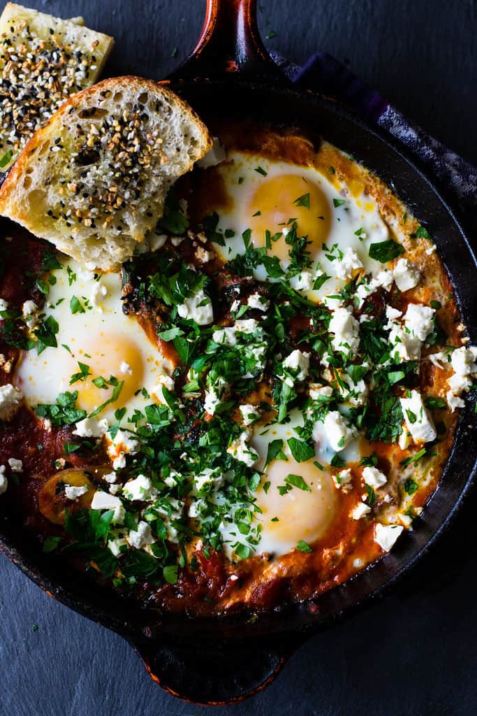 A hearty and smoky vegetarian shakshuka recipe loaded with sauteed kale, mushrooms and peppers. The tomato is seasoned with deep spices of cumin and paprika and once the dish is just done cooking, everything is topped with creamy feta and lots of fresh herbs. 