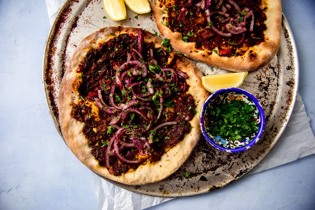 Vegan Turkish pizza AKA lahmacun is a thin crust pizza flavored with a bold and tangy vegetable mixture and topped with red onions and sumac.