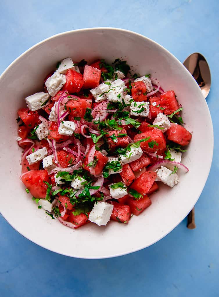 
You may not be able to stop once you dive into this bright and fresh Mediterranean watermelon salad. Sweet cubes of watermelon are gently tossed with creamy feta, thinly sliced onion and a simple sumac citrus dressing that makes all the bold flavors pop. Garnish the watermelon feta salad with a healthy amount of  fresh mint and basil for a spectacular and gorgeous summer salad.