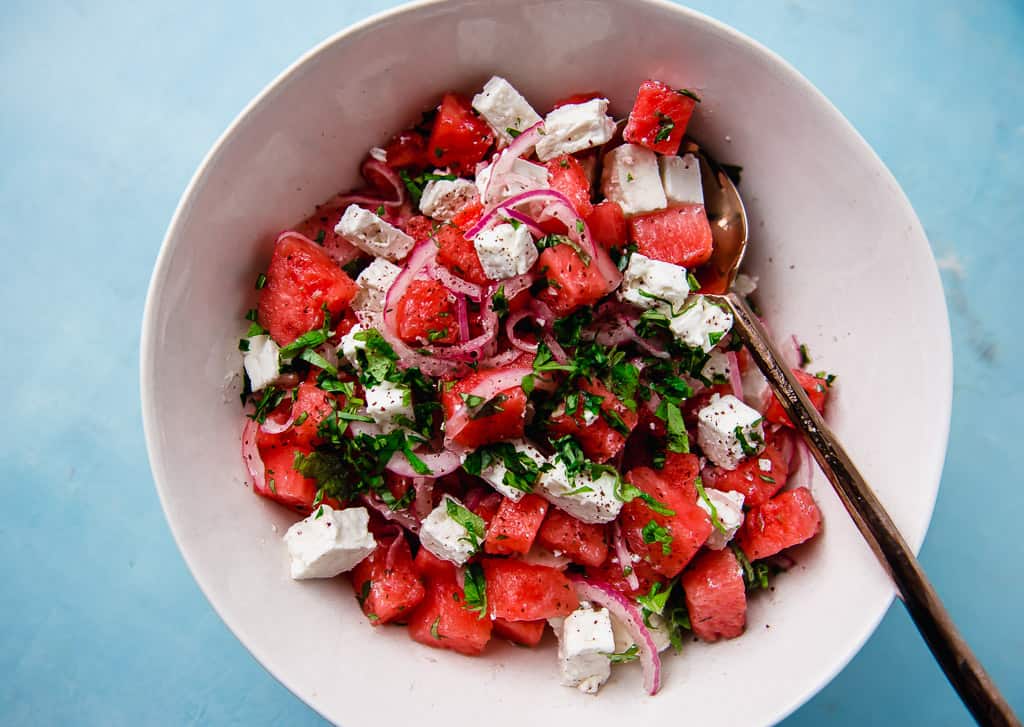 You may not be able to stop once you dive into this bright and fresh Mediterranean watermelon salad. Sweet cubes of watermelon are gently tossed with creamy feta, thinly sliced onion and a simple sumac citrus dressing that makes all the bold flavors pop. Garnish the watermelon feta salad with a healthy amount of  fresh mint and basil for a spectacular and gorgeous summer salad. 