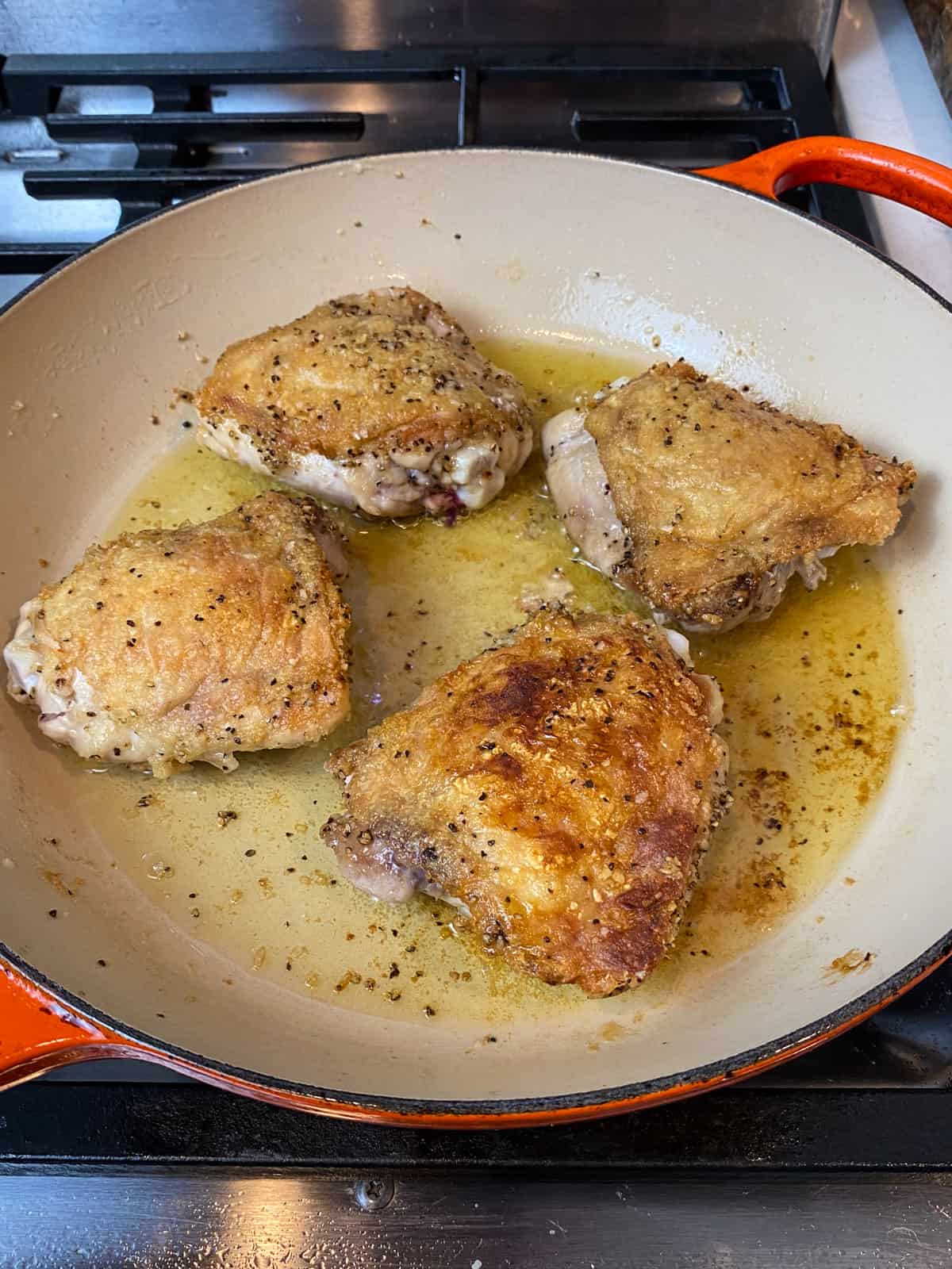 Sear the chicken thighs until the skin is golden brown.