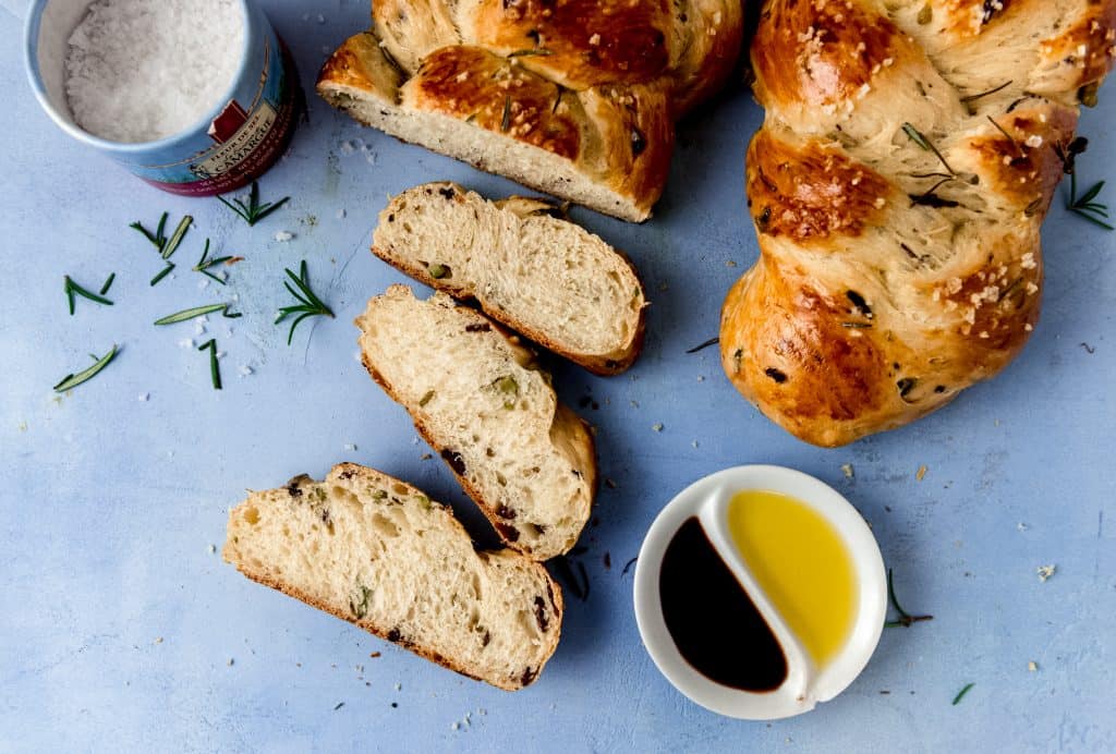 Savory olive oil challah is studded with chopped olives, fresh rosemary and finished with flakey sea salt.