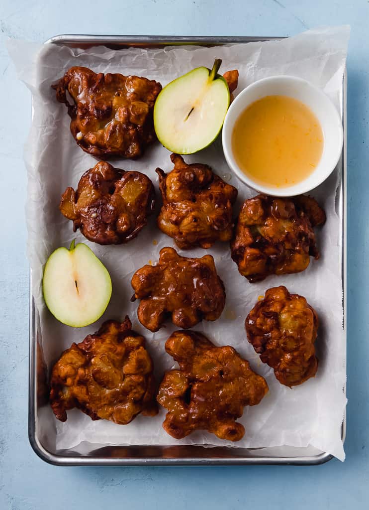 Pear fritters are sweet fried donuts that are seasoned with cinnamon and nutmeg and drizzled with a sweet orange glaze.