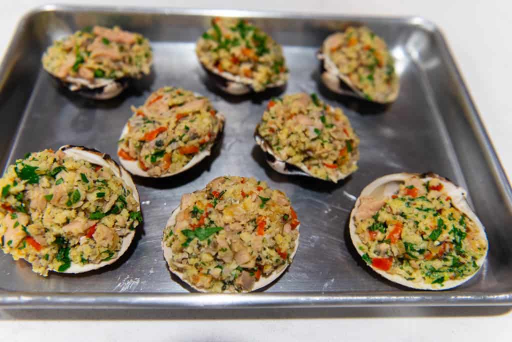 Baked clams casino are steamed clams that are stuffed with a mixture of shallots, peppers, panko and Parmesan cheese.