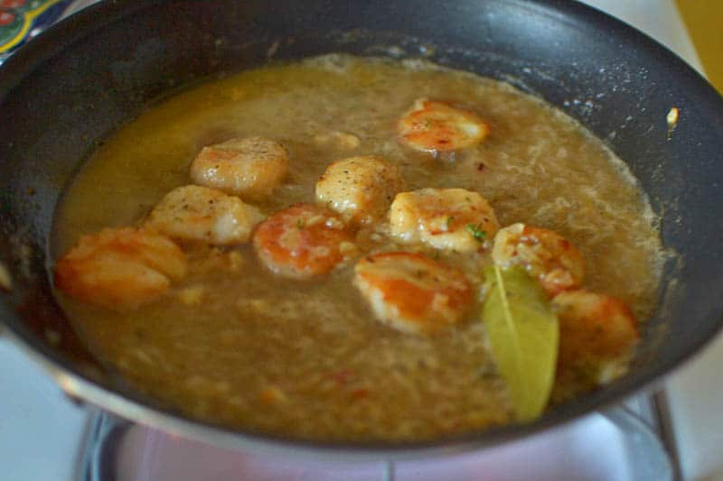 Pour wine into the same skillet with the scallops and add thyme, bay leaf and shallot mixture and continue cooking until wine is reduced, for another 2-3 minutes.