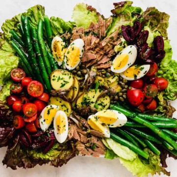 Julia Child's classic Salad Nicoise recipe filled is with olives, capers, and fresh vegetables all tossed with a simple vinaigrette.