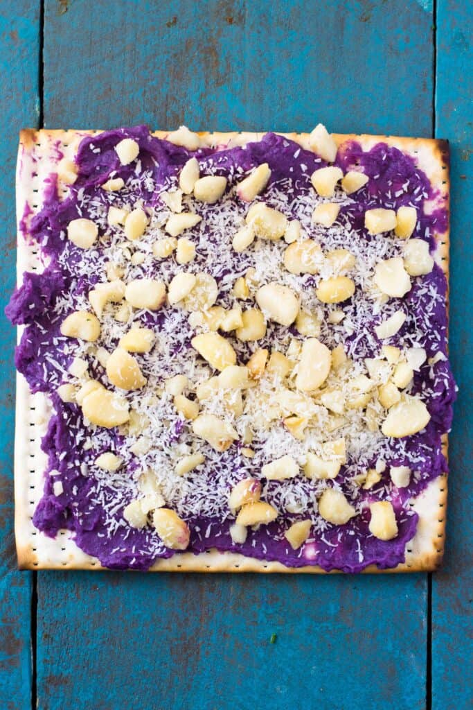 For the Hawaiian inspired matzo toppings, add coconut milk to boiled sweet purple potato and mash together until creamy. Spread a layer onto the matzo and top with chopped macadamia nuts and shredded coconut.