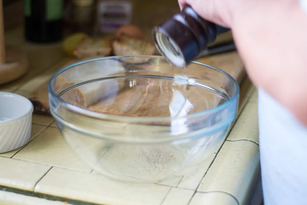 Start making Caesar dressing in a large bowl (a real wooden bowl is traditional), grind pepper (As much as you like, we did about 10-15 turns).