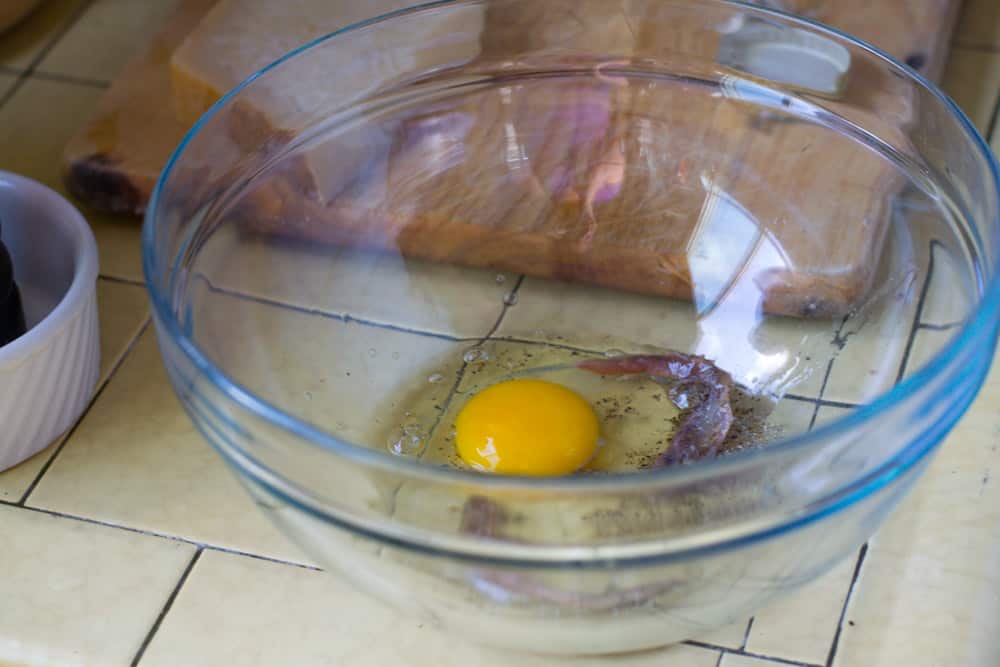 Add 1 egg yolk and using a wooden spoon, break up the egg and mix well.