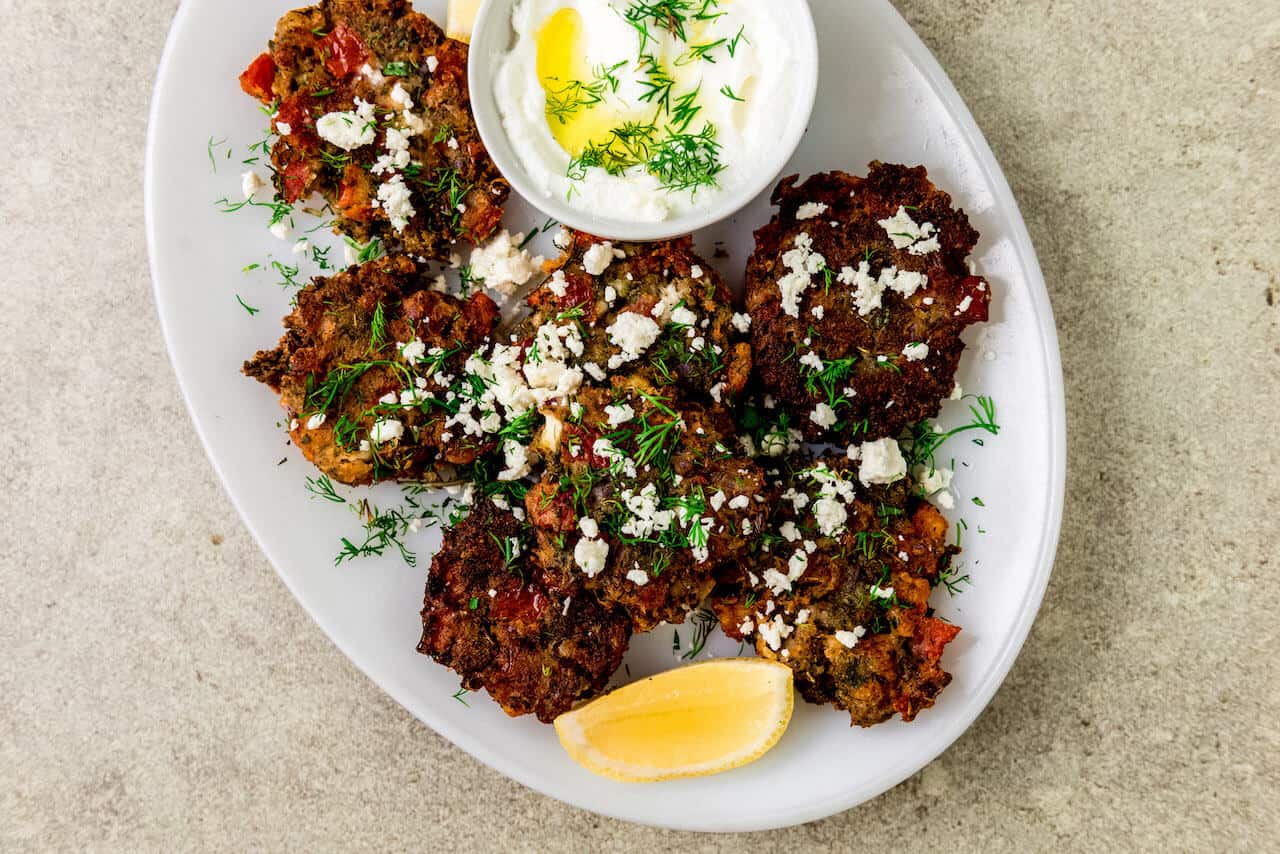 Greek tomato fritters are savory pancakes that are full of sweet tomatoes, fresh mint, dill and creamy feta cheese. The tomato fritters is fried until perfectly golden brown on both sides and served with a bright and lemony yogurt dill sauce.