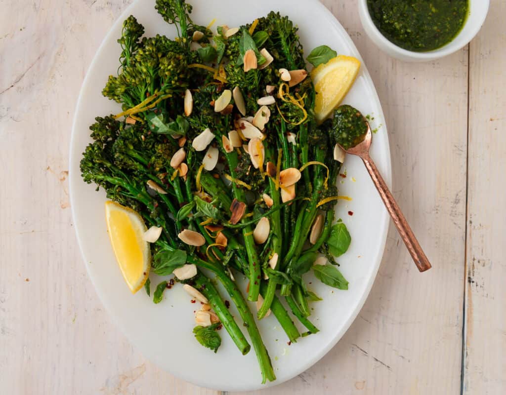 Roasted broccolini is tossed with an herbaceous pesto and garnished with toasted almonds, fresh lemon zest and a healthy drizzle of olive oil. 