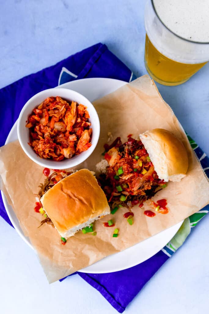 Hoisin pork is slow cooked for hours until fall apart and incredibly tender and then layered on top of sweet Hawaiian rolls with sharp kimchi. And an extra drizzle of sriracha for a bit more of a kick is highly encouraged.