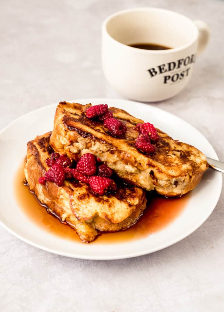 Stuffed challah French toast is stuffed with mashed banana and drizzled with a warm raspberry maple syrup. Served with a cup of coffee or tea.