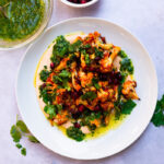 Honey harissa roasted cauliflower is layered on top of creamy harissa tahini and finished with a bright cilantro vinaigrette and sweet pomegranate seeds.