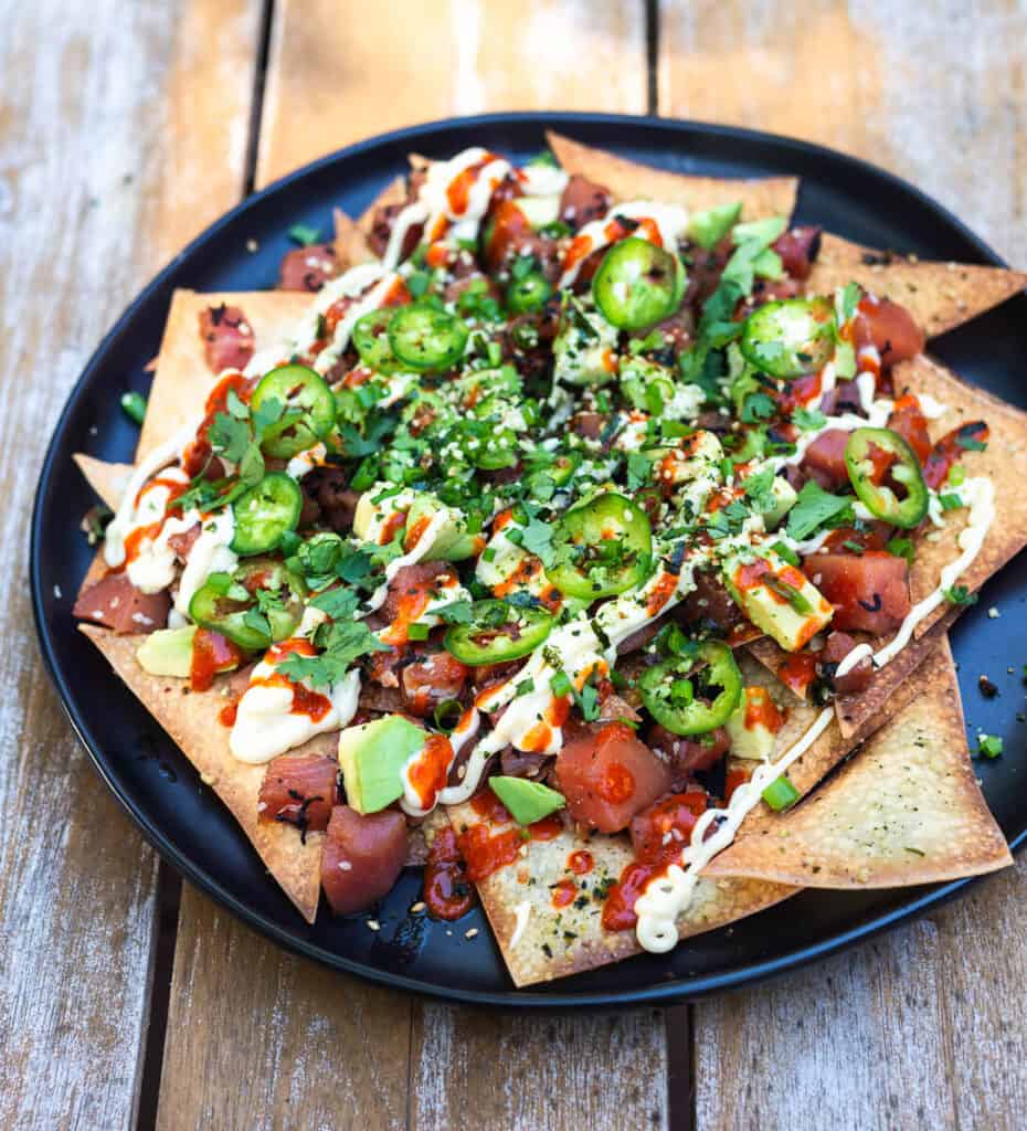 Poke nachos is a fun twist of cultural flavors. Seasoned Ahi poke is layered onto of baked wonton chips and garnished with a drizzle of sriracha, Japanese mayo, cubed avocado, fresh cilantro leaves and thinly sliced jalapeno.