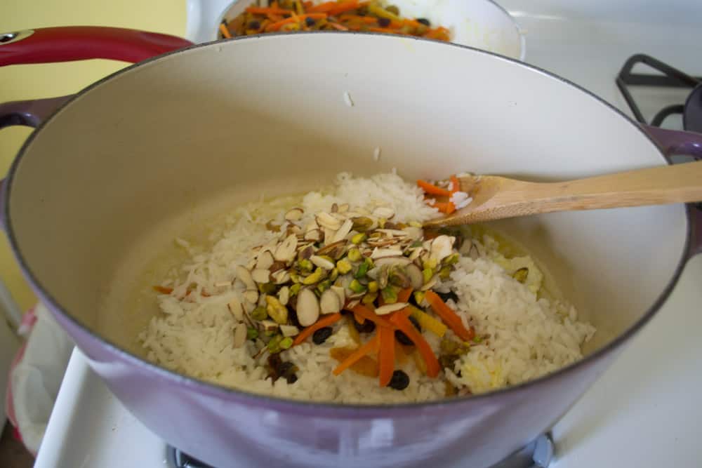To layer the Persian jeweled rice, add ⅓ of rice mixture, then ⅓ of fruit and nut mixture and continue until everything is used. Be sure to make a "pyramid" shape as you layer the rice.
