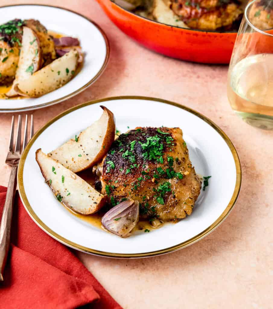 Honey Dijon chicken thighs are roasted in one pan with wedges of anjou pears and shallots until caramelized and tender. The chicken is garnished with chopped parsley and served with the roasted pears, shallots and pan sauce. 