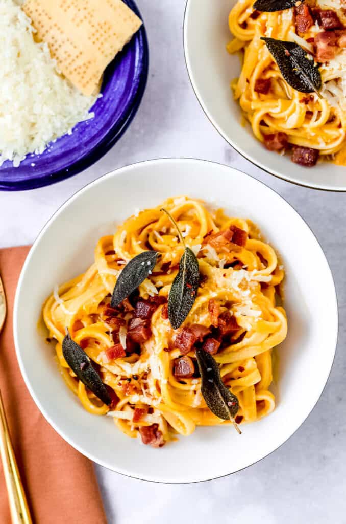 Cooked pasta is tossed with a creamy butternut squash pasta sauce and topped with cooked pancetta and a few leaves of fried sage. 