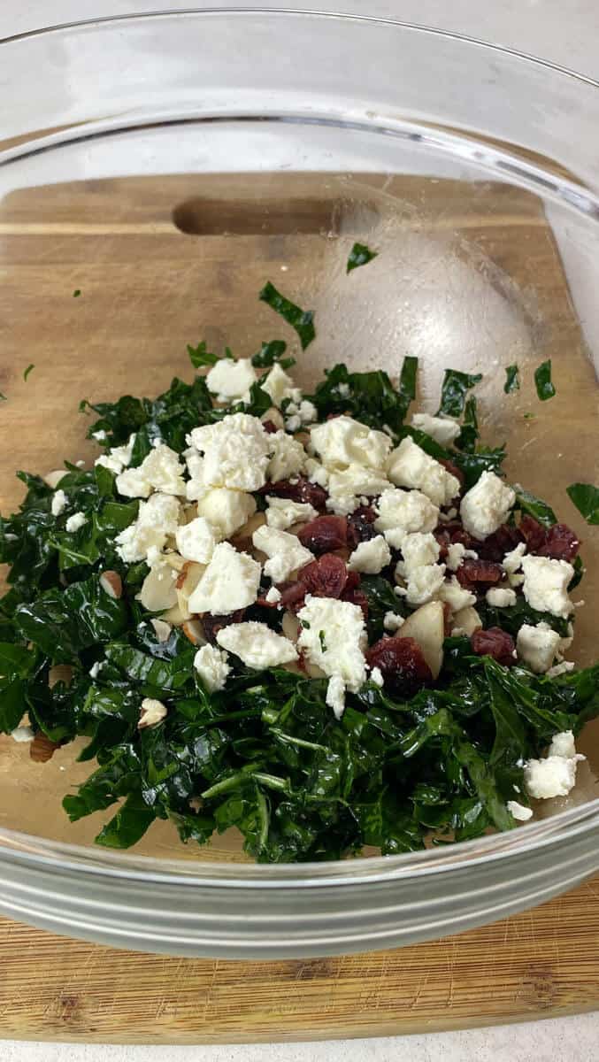 Crumbled feta cheese is added to the kale salad, along with dried cranberries and almonds.