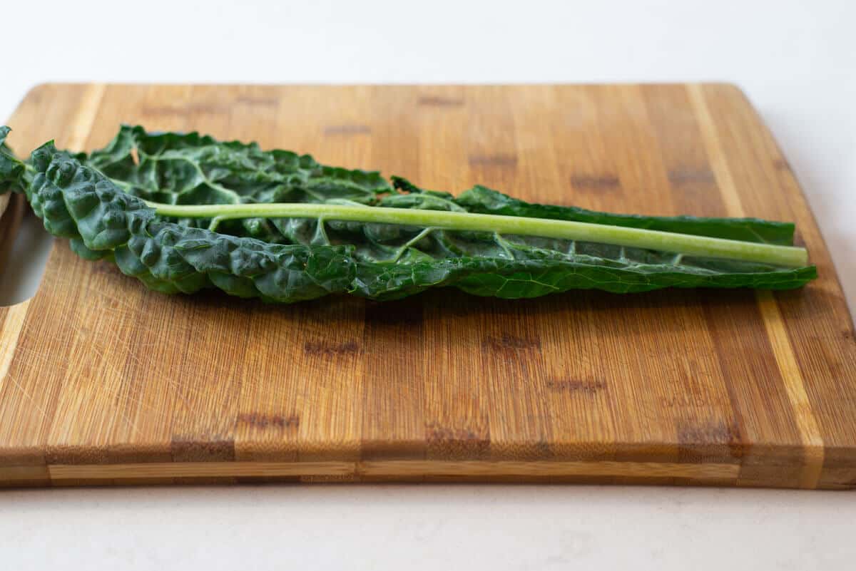 One leaf of fino kale on a cutting board.