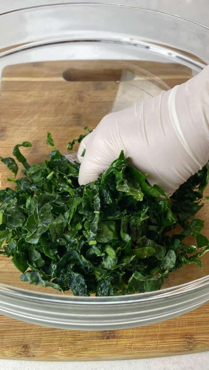 Massage the vinaigrette into the kale to tenderize the leaves.
