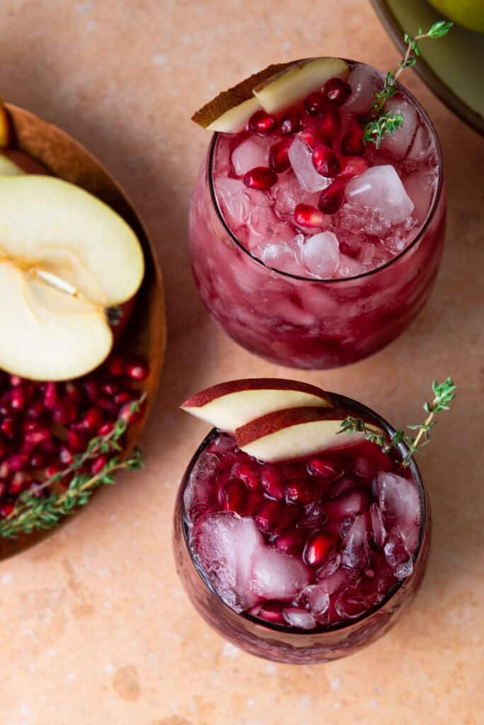 Two glasses of red wine sangria with pomegranate and pear.