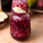 Pear and pomegranate sangria with pomegranate seeds and sliced pear.