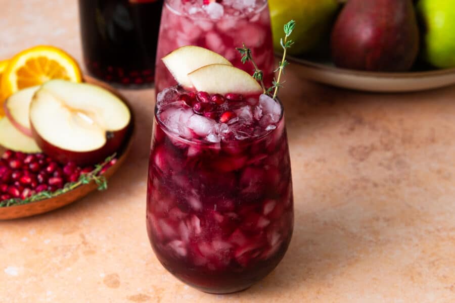 Pear and pomegranate sangria with pomegranate seeds and sliced pear.