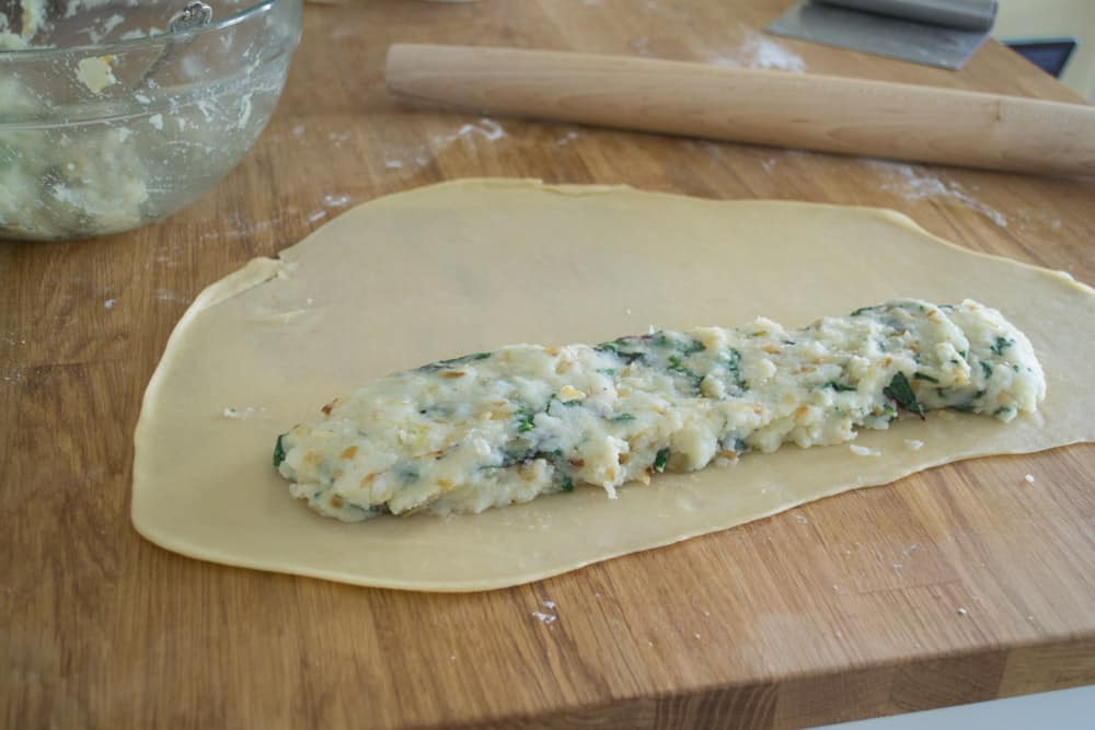 Add half of the mashed potato mixture onto the knish dough and form into a long log.