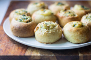 Potato knishes with sesame seeds on top.