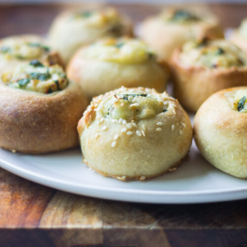 Potato knishes with sesame seeds on top.