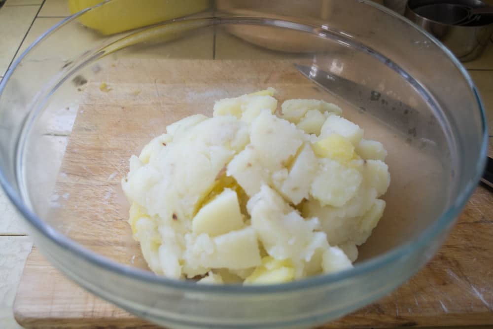 Peeled and cooked potatoes in a bowl about to be mashed.