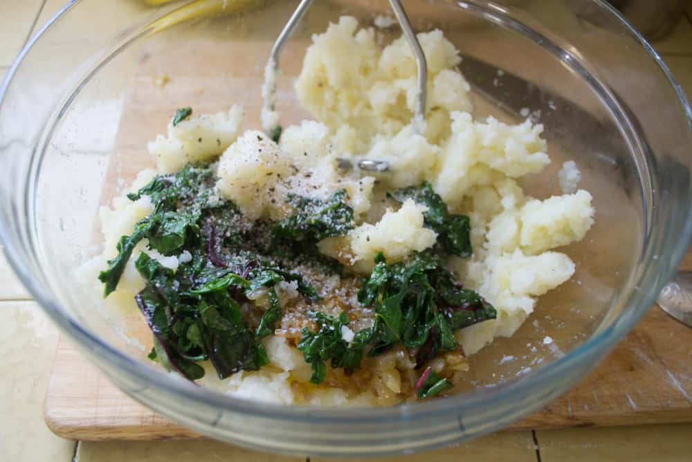 Mash the cooked potatoes and mix the sautéed spinach and caramelized onions in.