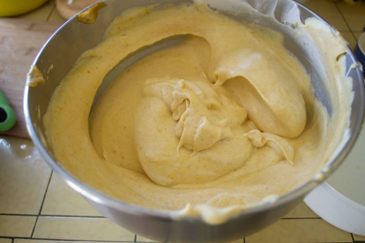 Uncooked pumpkin base is mixed into the beaten egg whites to make the pumpkin souffle.